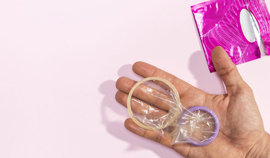 close-up-homem-segurando-unwrapped-preservativos